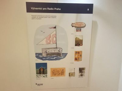 Nástěnná výstava s popisky „Výtvarníci pro Radio Praha“, koláž ilustrací a fotografií na bílém panelu.